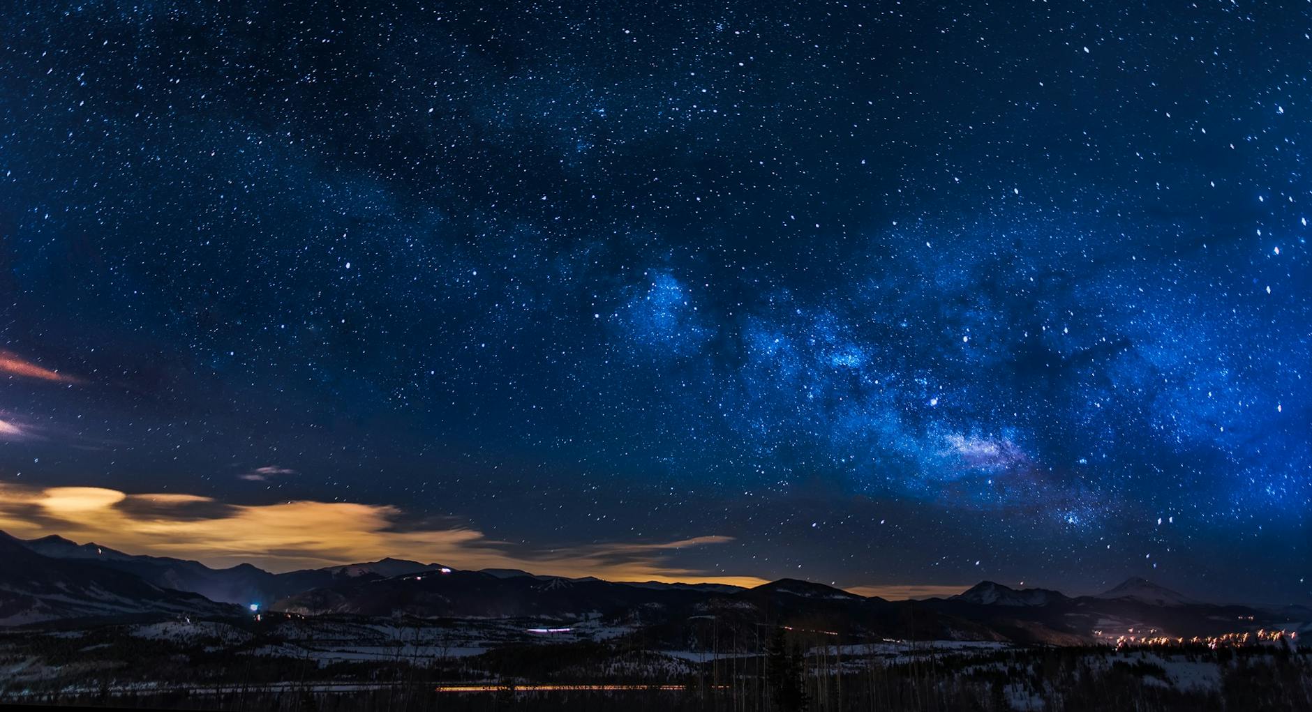 black mountains under the stars at nighttime